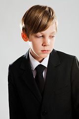 Image showing Serious young boy wearing black suit