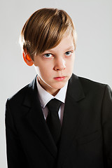 Image showing Serious young boy wearing black suit