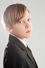 Image showing Serious young boy wearing black suit