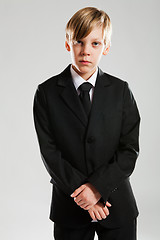 Image showing Serious young boy wearing black suit