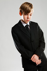 Image showing Serious young boy wearing black suit