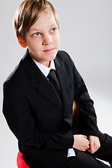 Image showing Smiling young boy wearing black suit