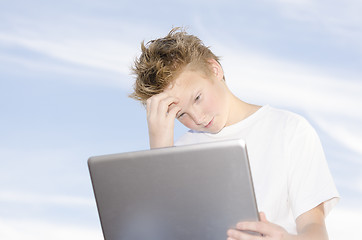 Image showing Youngster with laptop against blue sky