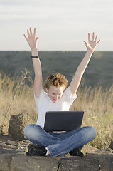 Image showing Teenager joyously throws his hands up