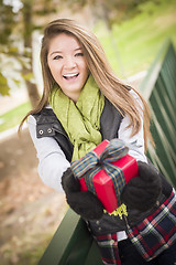 Image showing Pretty Woman with Wrapped Gift with Bow Outside