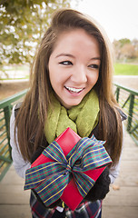 Image showing Pretty Woman with Wrapped Gift with Bow Outside