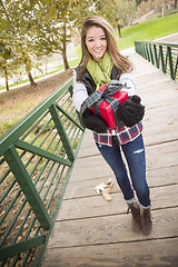 Image showing Pretty Woman with Wrapped Gift with Bow Outside