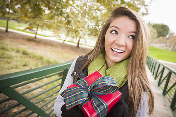 Image showing Pretty Woman with Wrapped Gift with Bow Outside