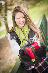 Image showing Pretty Woman with Wrapped Gift with Bow Outside