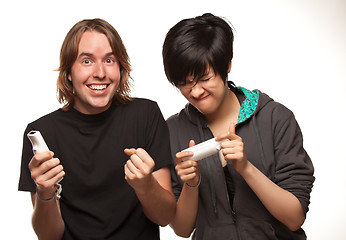 Image showing Mixed Race Couple Playing Video Game Remotes on White