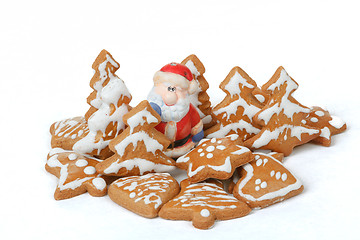 Image showing christmas gingerbreads and ceramic santa on white background