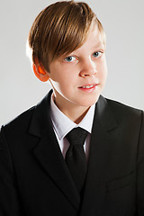 Image showing Smiling young boy wearing black suit