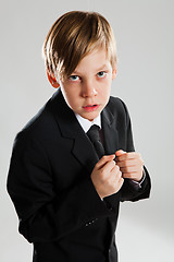 Image showing Serious young boy wearing black suit