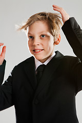 Image showing Smiling young boy wearing black suit