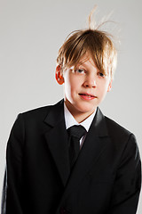 Image showing Happy relaxed young boy in black suit