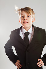 Image showing Happy relaxed young boy in black suit