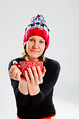 Image showing Smiling woman in knitted hat holding cup