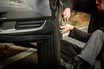 Image showing Young man repairing car