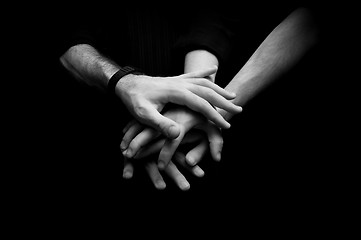 Image showing Group of young adults making a pile of hands