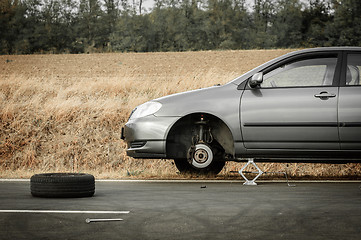 Image showing Car without tire on the road