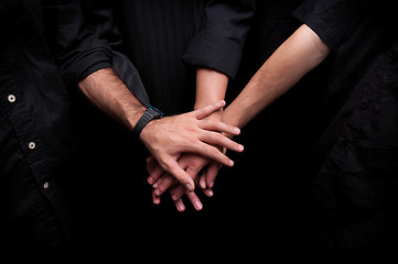 Image showing Group of young adults making a pile of hands