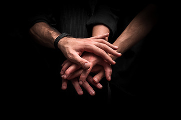 Image showing Group of young adults making a pile of hands