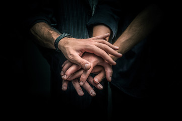 Image showing Group of young adults making a pile of hands