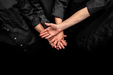 Image showing Group of young adults making a pile of hands