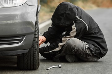 Image showing Young man repairing car outdoors