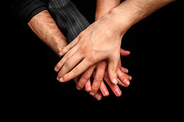 Image showing Group of young adults making a pile of hands