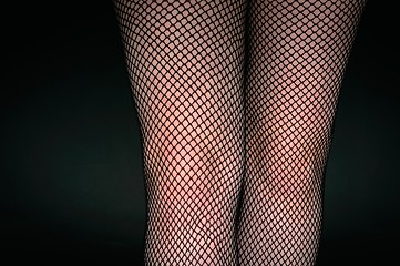 Image showing Legs of a youn woman against dark background
