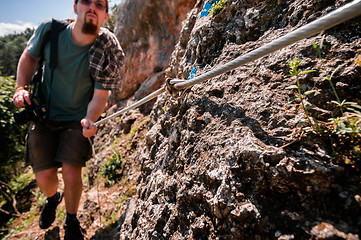 Image showing Young man climbing mountain