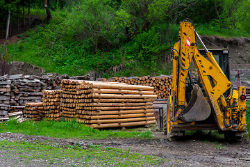 Image showing Construction machine and a pile of boards