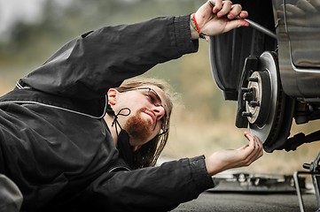 Image showing Handsome young man repairing car