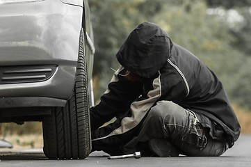 Image showing Young man repairing car outdoors