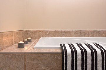 Image showing Bathtub, striped towel and candle lights