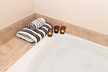 Image showing Towels, candle lights and bath with foam