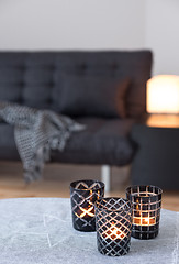 Image showing Tea-lights decorating living room with gray sofa