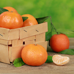 Image showing Tangerines with leaves in a wooden box