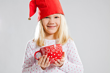 Image showing Smiling young girl holding big red cup
