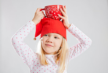 Image showing Happy young girl holding big cup on head