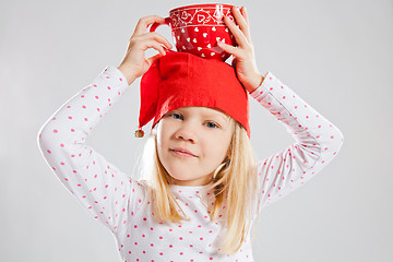 Image showing Happy young girl holding big cup on head