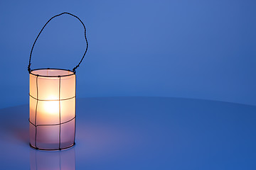 Image showing Cozy lantern on blue winter background