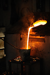 Image showing Foundry - Molten metal poured from lathe for casting