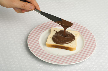 Image showing Liquid chocolate on a slice of bread