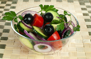 Image showing Salad in a glass bowl on a wooden base