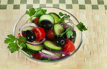 Image showing Salad in a glass bowl on a wooden base