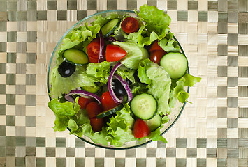 Image showing Salad in a glass bowl on a wooden base