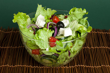 Image showing Salad in a glass bowl on a wooden base