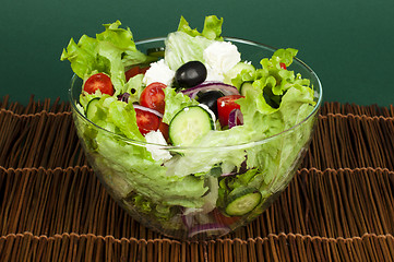 Image showing Salad in a glass bowl on a wooden base